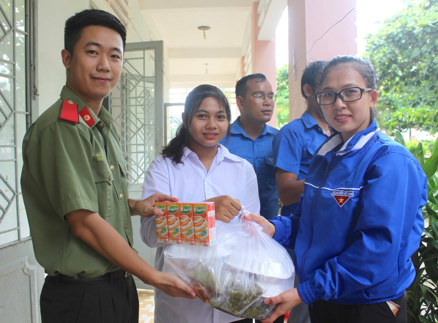 Các tình nguyện viên hỗ trợ cơm trưa và sữa cho các em học sinh Trường THPT Phan Chu Trinh dự thi tại điểm thi Trường THPT Nguyễn Tất Thành (huyện Ia Pa). Ảnh: Vũ Chi