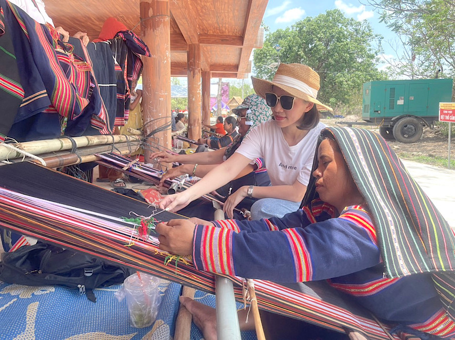 Chị Nguyễn Thị Ngọc Lê (áo trắng) từ Thủ đô Hà Nội trở về quê hương Phú Thiện để tham gia các hoạt động tại lễ hội cầu mưa ở Plei Ơi, xã Ayun Hạ. Ảnh: Vũ Chi