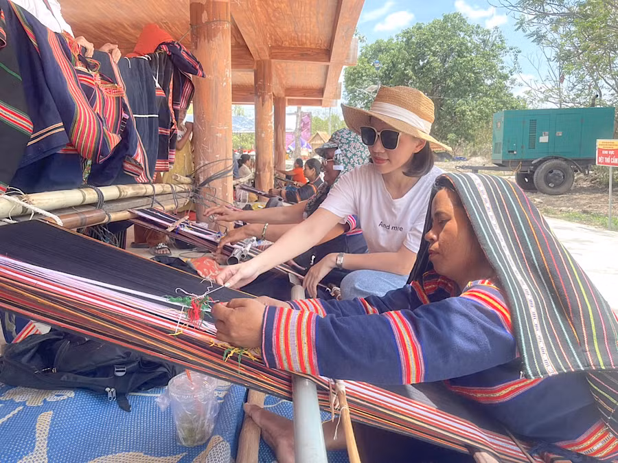 Chị Nguyễn Thị Ngọc Lê (áo trắng) từ Thủ đô Hà Nội trở về quê hương Phú Thiện để tham gia các hoạt động tại lễ hội cầu mưa ở Plei Ơi, xã Ayun Hạ. Ảnh: Vũ Chi