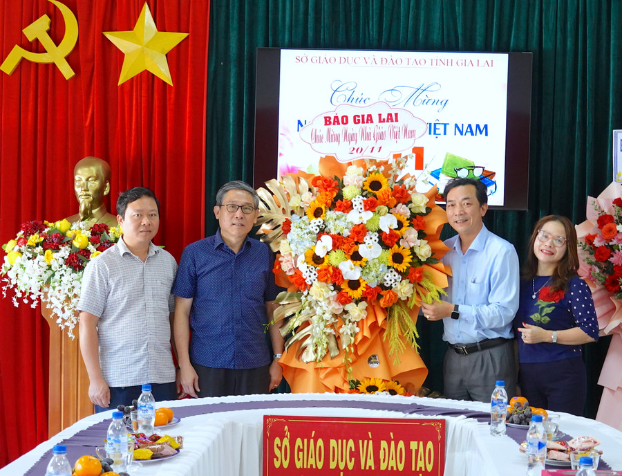 Giám đốc Sở GD-ĐT Lê Duy Định (thứ 2 từ trái sang) đón nhận lẵng hoa chúc mừng của Báo Gia Lai nhân kỷ niệm 41 năm Ngày Nhà giáo Việt Nam. Ảnh: Mộc Trà