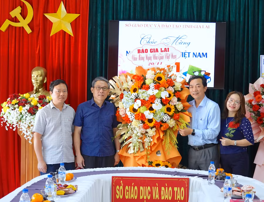 Giám đốc Sở GD-ĐT Lê Duy Định (thứ 2 từ trái sang) đón nhận lẵng hoa chúc mừng của Báo Gia Lai nhân kỷ niệm 41 năm Ngày Nhà giáo Việt Nam. Ảnh: Mộc Trà