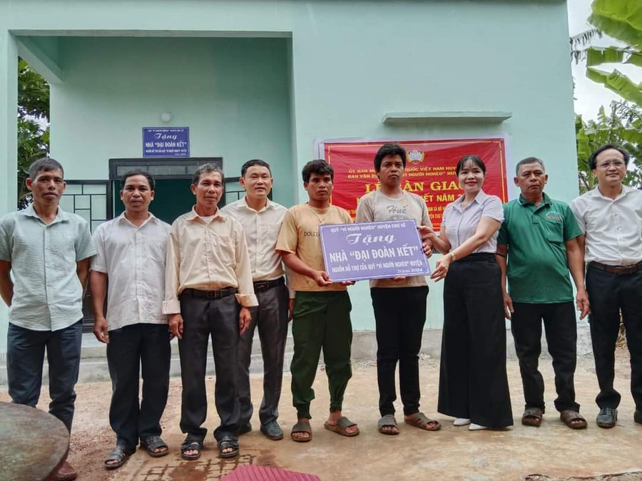 Bà Đinh Thị Thông-Chủ tịch Ủy ban MTTQ Việt Nam huyện Chư Sê (thứ 3 từ phải sang) bàn giao nhà "Đại đoàn kết" cho gia đình ông Xưng (làng Thoong Nha, xã Bờ Ngoong). Ảnh: Ngọc Anh