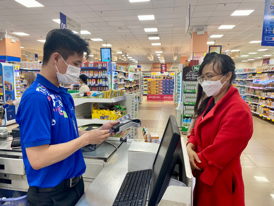 Người dân sử dụng dịch vụ thanh toán không dùng tiền mặt khi mua sắm tại Siêu thị Co.op Mart Pleiku. Ảnh: Mộc Trà