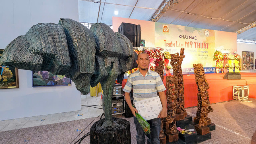 Nhà điêu khắc Nguyễn Vinh bên tác phẩm “Cao nguyên xanh” (bên trái) tại triển lãm. Ảnh: Hùng Hoa Lư