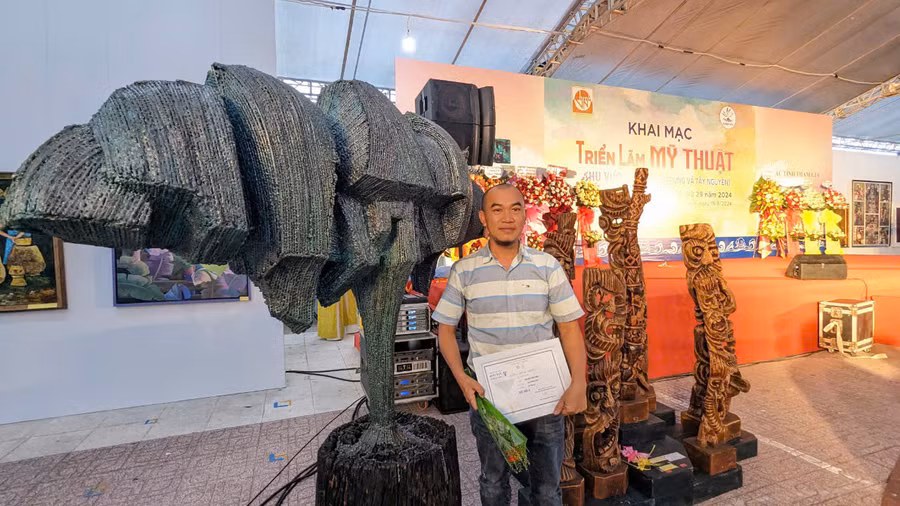 Nhà điêu khắc Nguyễn Vinh bên tác phẩm “Cao nguyên xanh” (bên trái) tại triển lãm. Ảnh: Hùng Hoa Lư