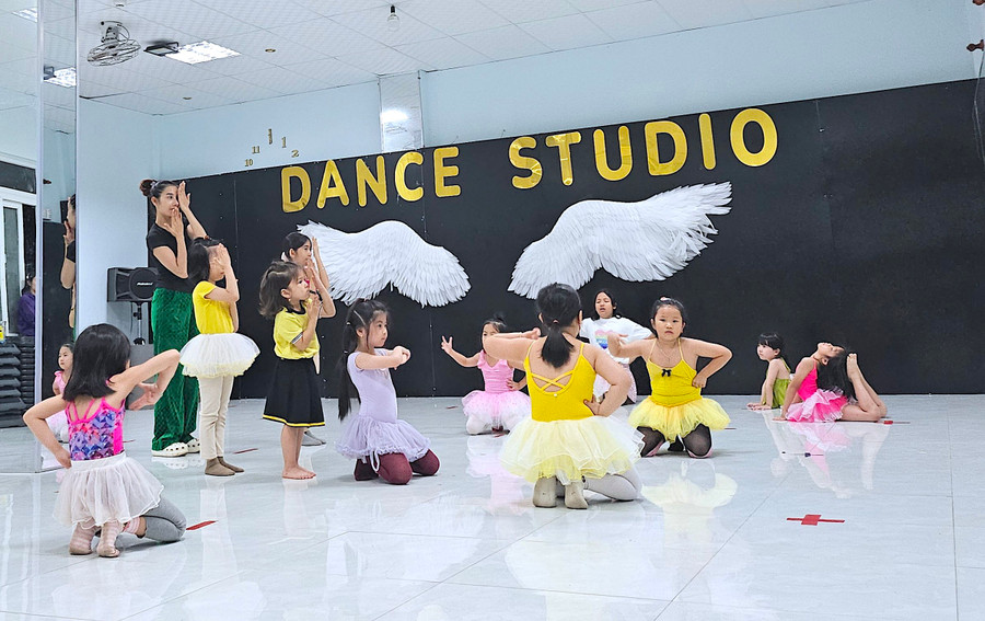 Chị Từ Hoàng Oanh hướng dẫn các bé trong đội múa ballet tập luyện vũ đạo trên nền nhạc của ca khúc Hoa cỏ mùa xuân. Ảnh: Mộc Trà Chị Từ Hoàng Oanh hướng dẫn các bé trong đội múa ballet tập luyện vũ đạo trên nền nhạc của ca khúc Hoa cỏ mùa xuân. Ảnh: Mộc Trà