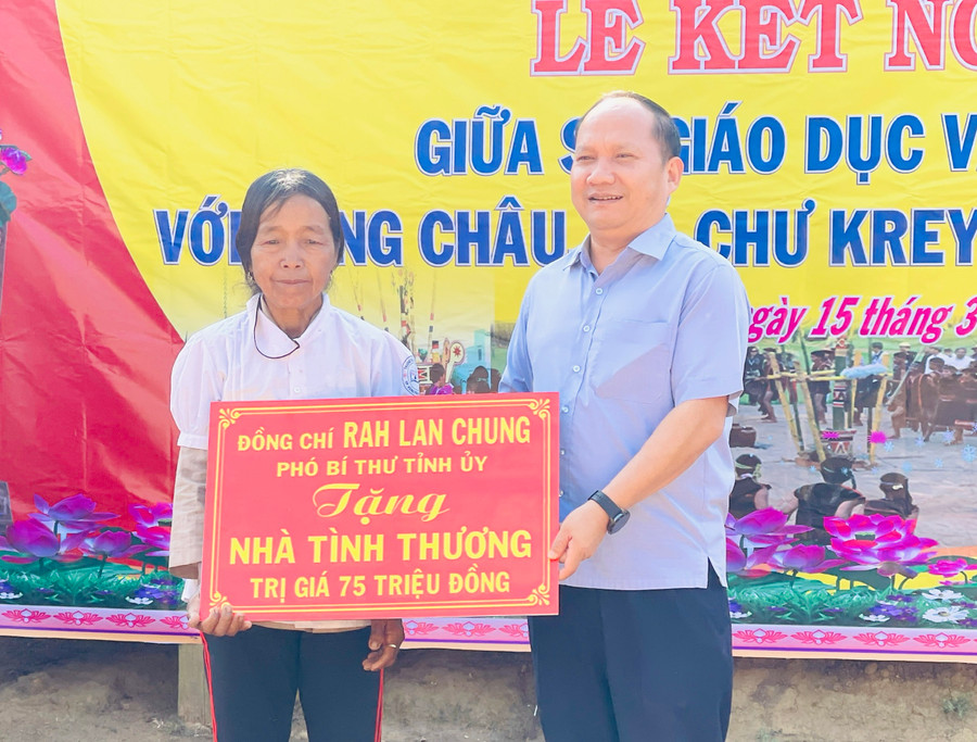 Phó Bí thư Tỉnh ủy Rah Lan Chung tặng căn nhà tình thương cho gia đình bà Đinh Thị Bleng-hộ nghèo của làng Châu. Ảnh: Mai Ka
