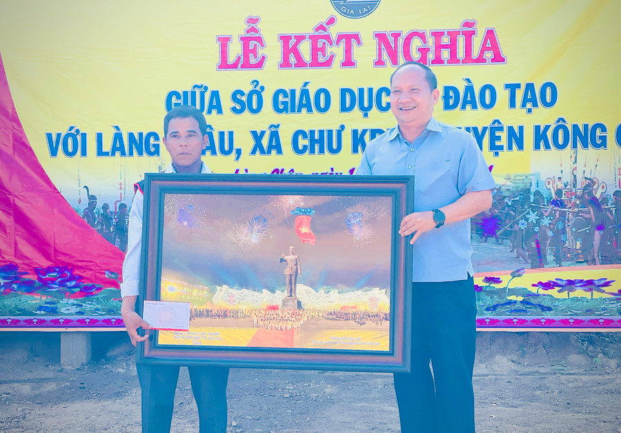 Phó Bí thư Tỉnh ủy Rah Lan Chung (bìa phải) tặng phần quà cho tập thể làng Châu. Ảnh: Mai Ka