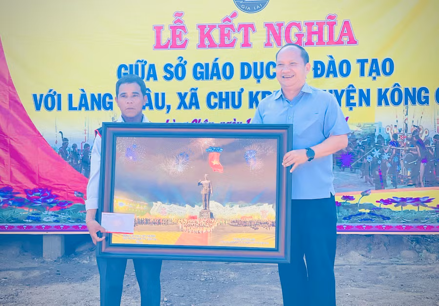 Phó Bí thư Tỉnh ủy Rah Lan Chung (bìa phải) tặng phần quà cho tập thể làng Châu. Ảnh: Mai Ka