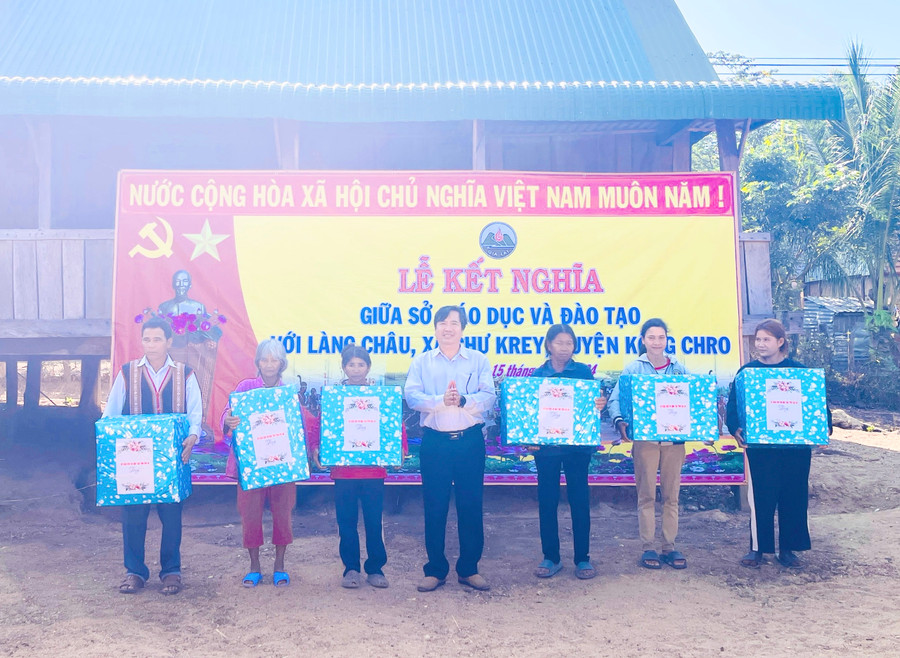 Sở Giáo dục và Đào tạo tặng quà cho các hộ nghèo làng Châu. Ảnh: Mai Ka