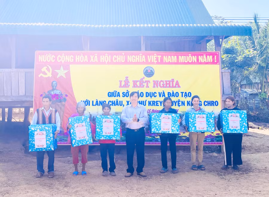 Sở Giáo dục và Đào tạo tặng quà cho các hộ nghèo làng Châu. Ảnh: Mai Ka