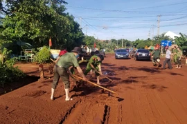 Đoàn viên thanh niên Công an Đức Cơ dọn bùn đất trên quốc lộ sau mưa lớn