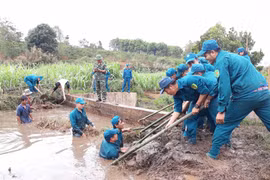 Dân quân tự vệ giúp dân dọn dẹp vệ sinh đường làng, giọt nước