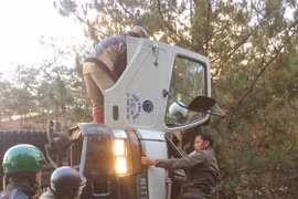 Xe tải lật ngang, tài xế mắc kẹt trong cabin