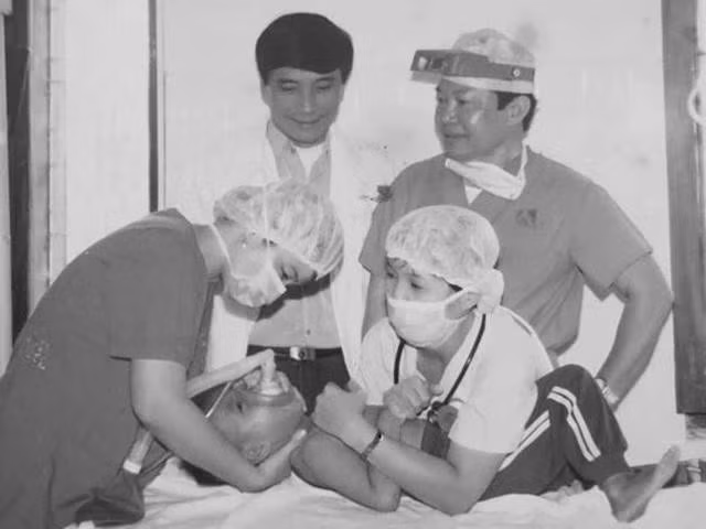 Bác sĩ Trần Thành Trai (đứng, bên phải) đang chỉ đạo ca mổ cho một cháu bé. ẢNH: TL