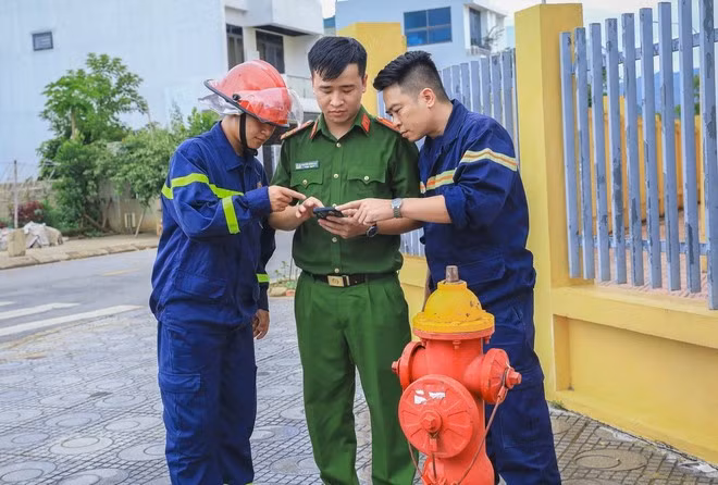 Thượng úy Nguyễn Doãn Đạt (giữa) kiểm tra các trụ nước theo định vị GPS trên ứng dụng bản đồ nguồn nước. (Ảnh: Xuân Tư/TTXVN)