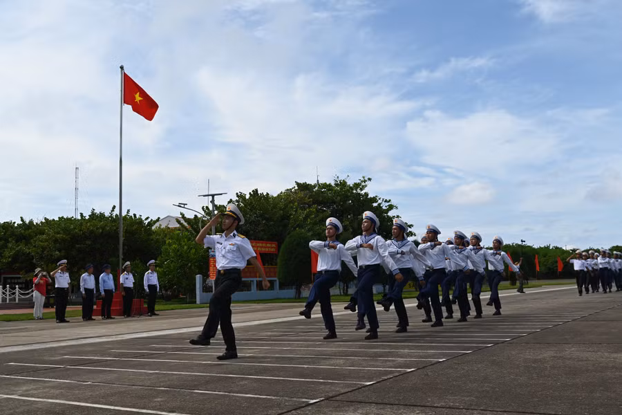 Lãnh đạo Đoàn công tác số 25 và các thành viên tham gia lễ chào cờ và duyệt đội ngũ của các lực lượng cán bộ, chiến sĩ đóng quân tại Trường Sa Lớn.
