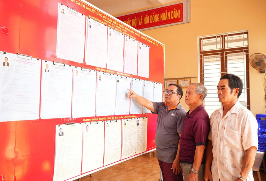 Ông Trần Đức Thảo (thứ 3 từ phải sang, Trưởng khu phố Thiện Chánh 2, phường Hoài Nhơn Bắc) và các thành viên tổ bầu cử kiểm tra lại bảng thông tin về các ứng cử viên. Ảnh: Quang Hải