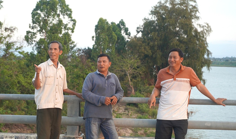 Ông Nguyễn Văn Thoa (bên trái) phấn khởi chỉ cho thế hệ sau thấy những đổi thay mạnh mẽ của thôn Hưng Hà so với trước đây.