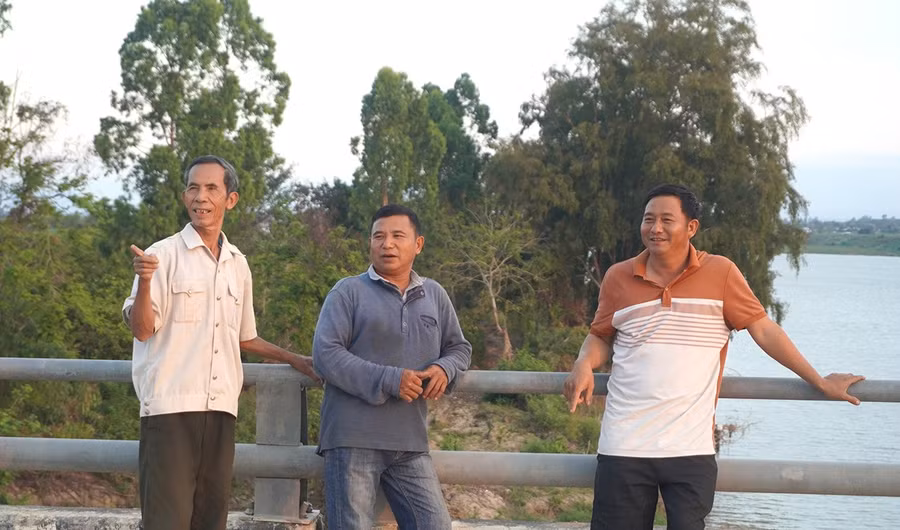 Ông Nguyễn Văn Thoa (bên trái) phấn khởi chỉ cho thế hệ sau thấy những đổi thay mạnh mẽ của thôn Hưng Hà so với trước đây.