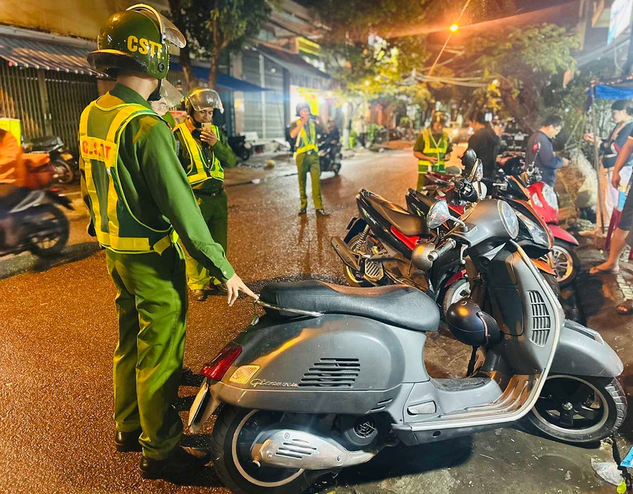 Lực lượng Cảnh sát trật tự nhắc nhở người dân ở phường Quy Nhơn Nam về việc dựng xe lấn chiếm lòng đường. Ảnh: K.A