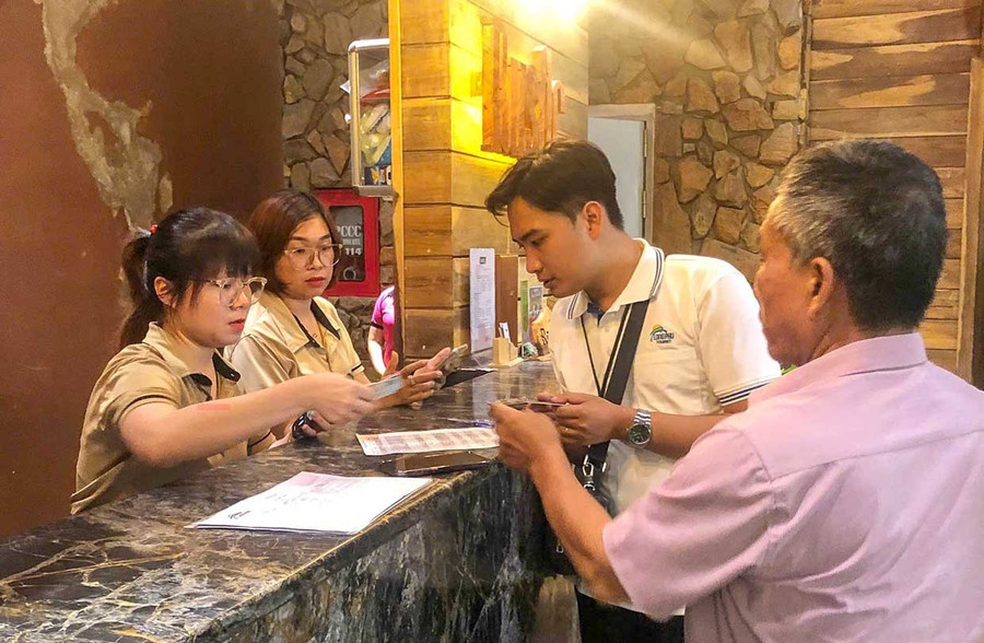 Nhân viên lễ tân khách sạn Rustic (phường Quy Nhơn) đón khách lưu trú. Ảnh: Đoan Ngọc