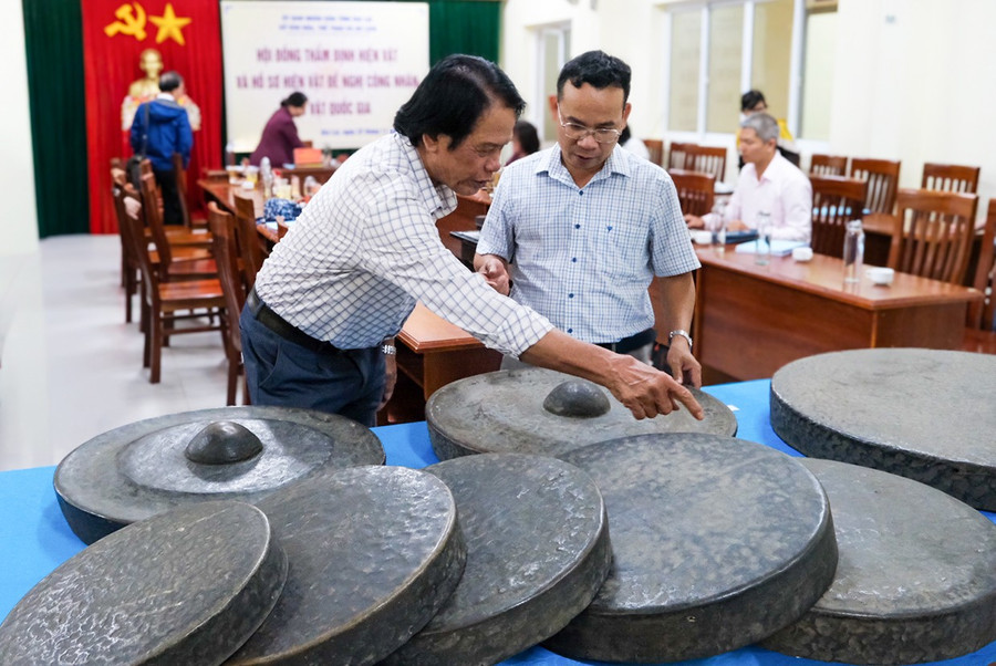 Nghệ nhân Ưu tú Nay Phai (bìa trái) giới thiệu hệ thang âm độc đáo của bộ chiêng Kơ Đơ - bảo vật quốc gia mới của tỉnh Gia Lai. Ảnh: Minh Châu