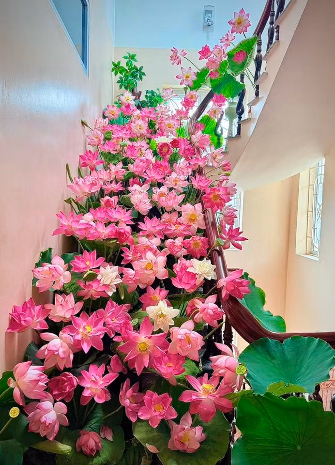 Chị Hương dùng hoa sen cắm khắp cầu thang. Vì các thành viên trong gia đình ít khi đi lại ở tầng 4 nên chị có thể thoải mái cắm hoa ở đây. ẢNH: NVCC