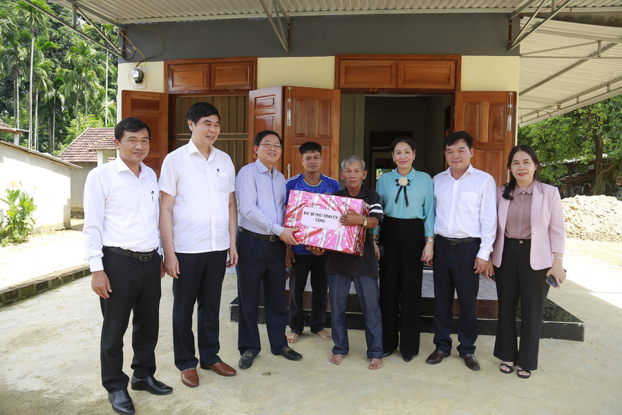 Bí thư Tỉnh ủy Hồ Quốc Dũng (thứ ba, từ trái qua) đến thăm và tặng quà gia đình ông Đinh Văn Túc (hộ nghèo) ở khu phố 2, thị trấn An Lão (nay là xã An Lão). Ảnh: HỒNG PHÚC 63.jpg
