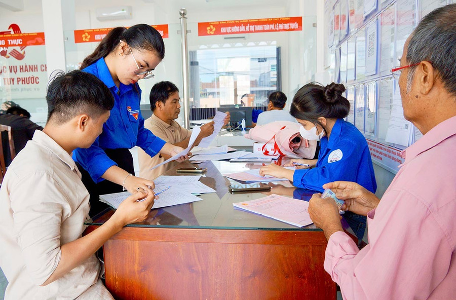 Các xã, phường cử thêm cán bộ, đoàn viên thanh niên hỗ trợ người dân khi đến thực hiện thủ tục hành chính tại Trung tâm Phục vụ hành chính công. Ảnh: Nguyễn Muội lay11chot.jpg