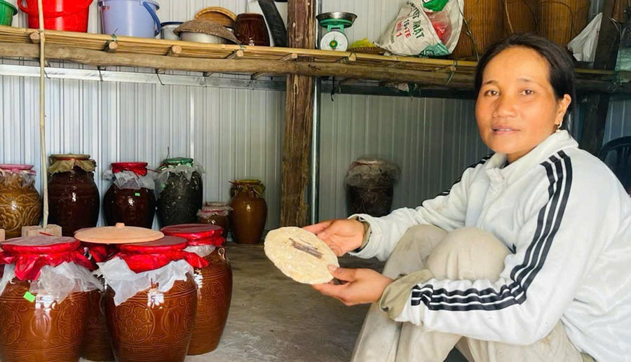 Chị Đinh Thị Em (làng Jun, xã Đak Pơ) bên những ché rượu cần từ hạt cào ủ với men lá. Ảnh: H.T 2t.jpg