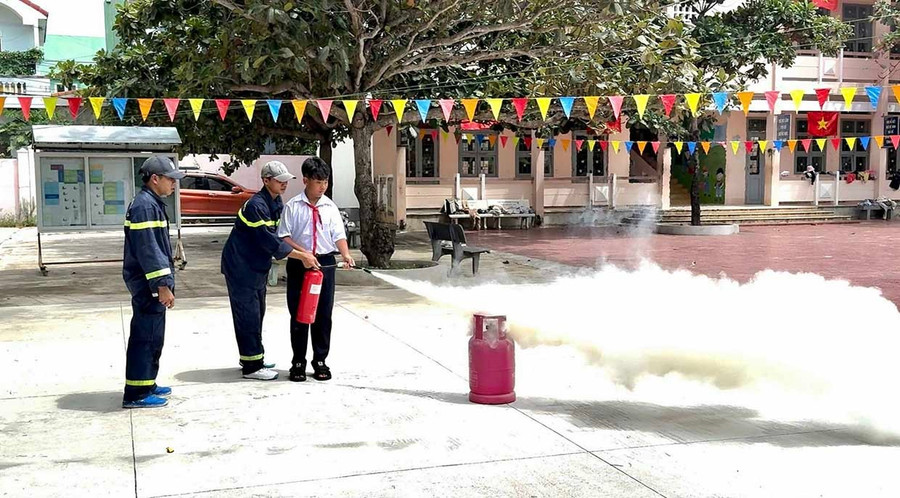 Học sinh Trường THCS Nhơn Lý (phường Quy Nhơn Đông) được hướng dẫn cách dùng bình chữa cháy xách tay để ngăn cháy từ bình gas. Ảnh: K.A bg8-1.jpg