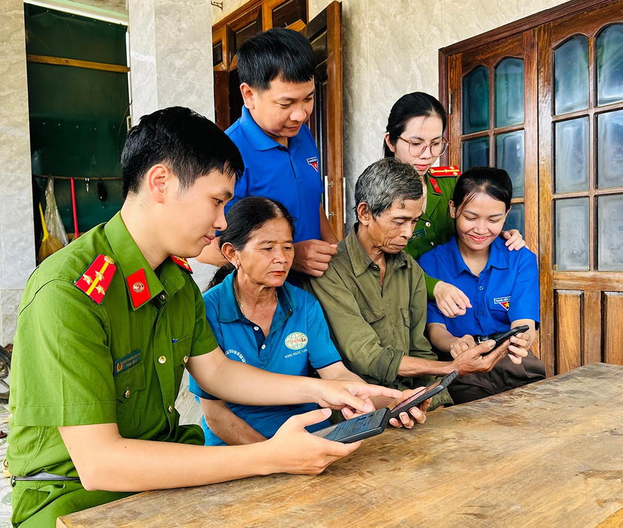 Thành viên Tổ công nghệ số cộng đồng thôn 6 (xã An Lão) hướng dẫn người dân cài đặt ứng dụng VneID. Ảnh: D.Đ