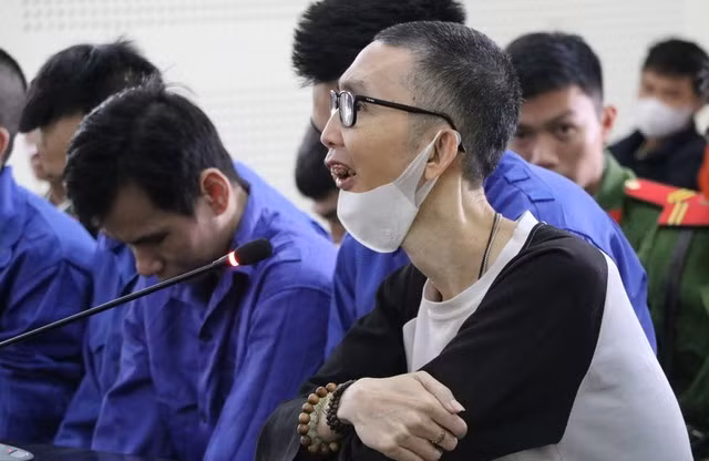 Nguyễn Đức Vinh (đeo kính) tại phiên tòa. Ảnh: H. Tây