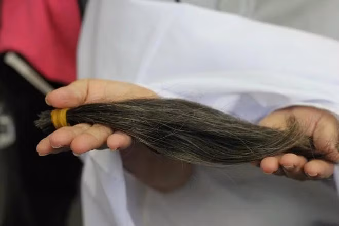 Anh Hoàng Anh cắt tóc cho bà Thu Hà. ẢNH: THÁI THANH