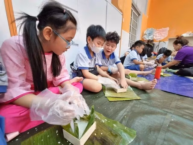 Học sinh TP.HCM học gói bánh chưng đón tết. ẢNH: ĐÀO NGỌC THẠCH