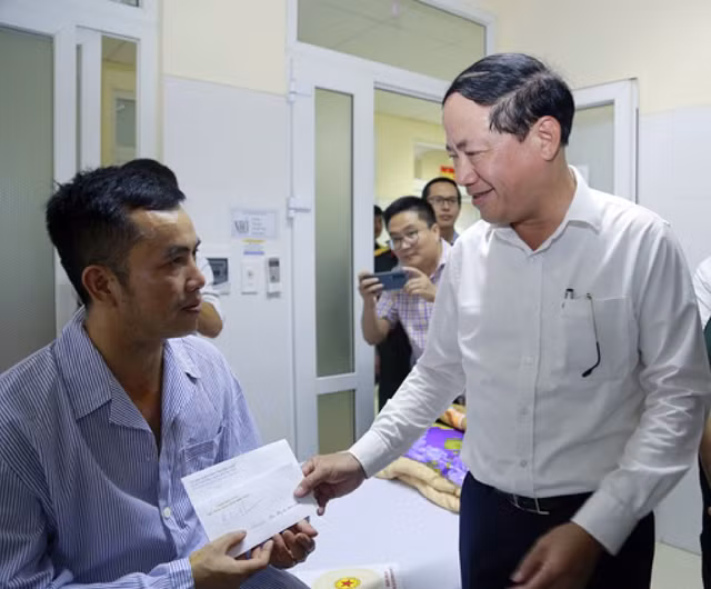 Chủ tịch UBND tỉnh Bình Định Phạm Anh Tuấn trào quà cho phi công Nguyễn Hồng Quân. Ảnh Đức Anh