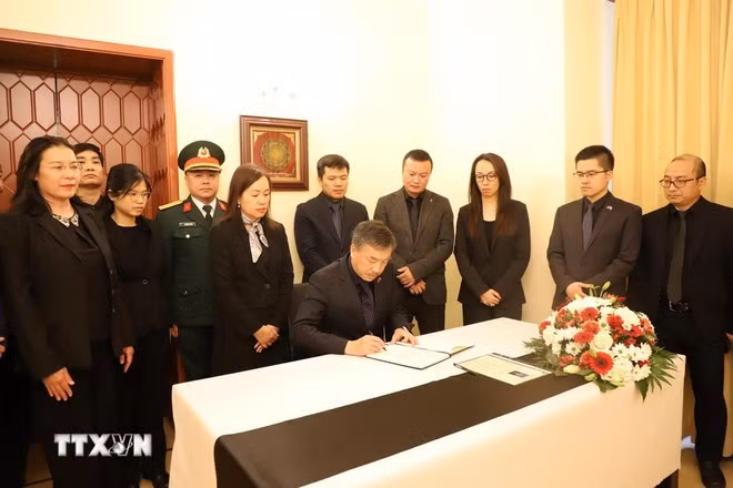 Đại sứ Dương Hoài Nam mở đầu nghi thức ghi sổ tang nguyên Chủ tịch nước Trần Đức Lương. (Ảnh: Việt Dũng/TTXVN)