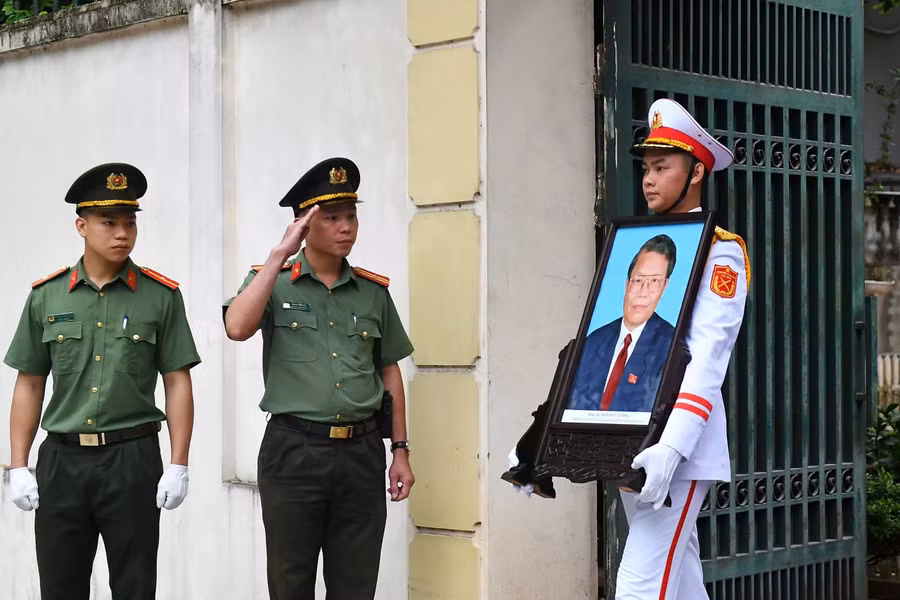 Tại đây đoàn xe đã dừng lại 5 phút, đưa di ảnh nguyên Chủ tịch nước Trần Đức Lương vào nhà rồi tiếp tục di chuyển đến sân bay Nội Bài. ẢNH: TUẤN MINH