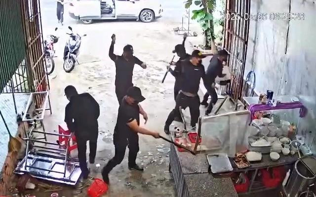 Nhóm người mặc đồ đen vào đập phá quán phở. ẢNH: CẮT TỪ CLIP Nhóm người mặc đồ đen vào đập phá quán phở. ẢNH: CẮT TỪ CLIP