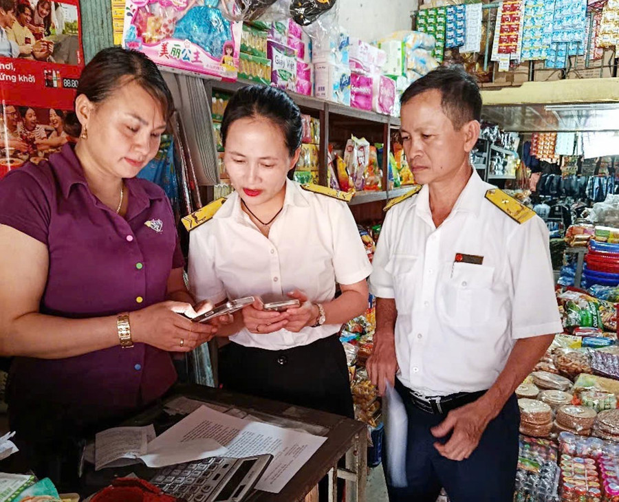 Công chức Đội thuế liên huyện Đông Gia Lai đến gặp từng hộ kinh doanh để tuyên truyền, hướng dẫn về hóa đơn điện tử. Ảnh: S.C 1bg.jpg