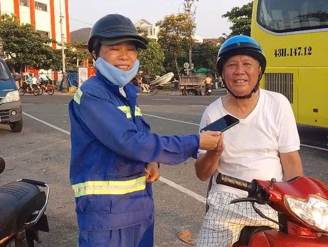 Chị Lê Thị Thanh Phương trả lại điện thoại cho ông Huỳnh Văn Danh. ẢNH: NGUYỄN TÚ