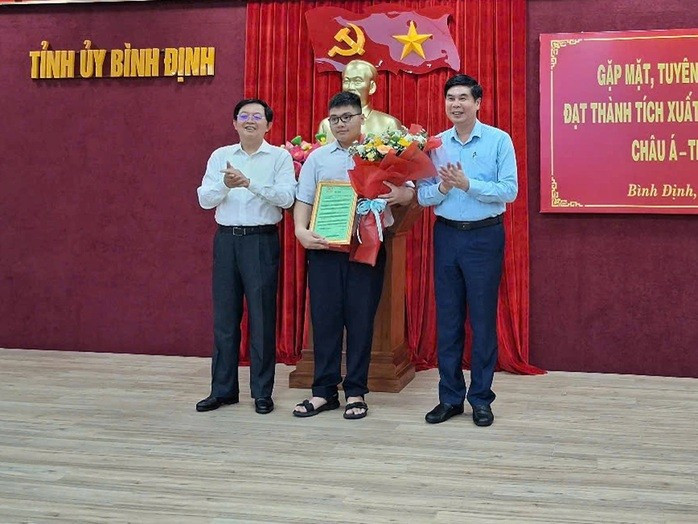 Bí thư Tỉnh ủy Bình Định Hồ Quốc Dũng (bên trái) và Phó Chủ tịch UBND tỉnh Bình Định Lâm Hải Giang (bên phải) trao thưởng cho em Lê Kiến Thành. ẢNH: OANH TRƯỞNG Bí thư Tỉnh ủy Bình Định Hồ Quốc Dũng (bên trái) và Phó Chủ tịch UBND tỉnh Bình Định Lâm Hải Giang (bên phải) trao thưởng cho em Lê Kiến Thành. ẢNH: OANH TRƯỞNG