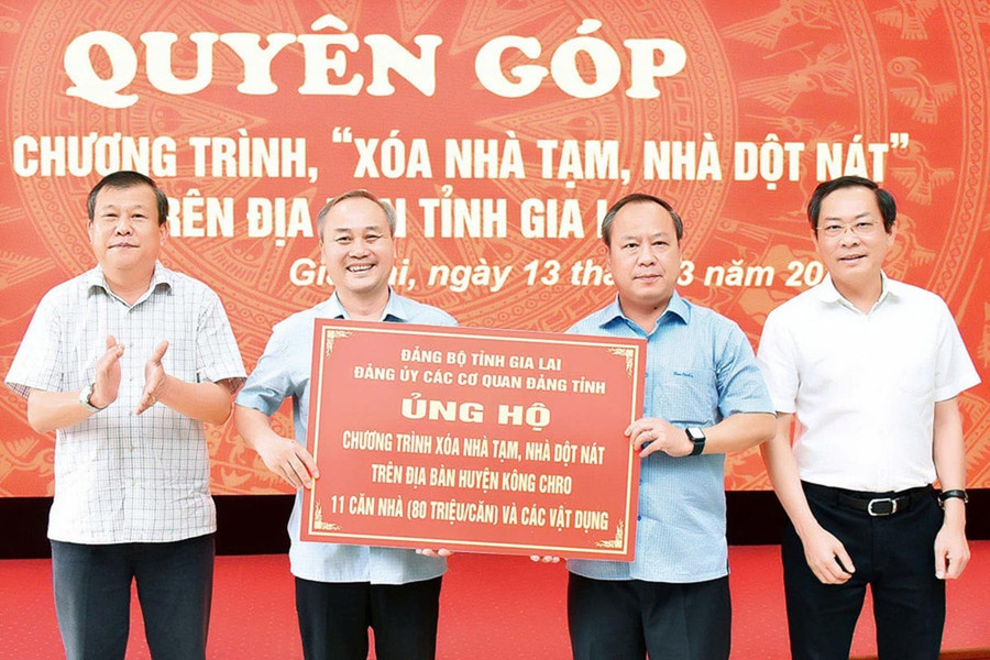 Phó Bí thư Thường trực Tỉnh ủy, Trưởng đoàn đại biểu Quốc hội tỉnh, Bí thư Đảng ủy các cơ quan Đảng tỉnh Châu Ngọc Tuấn (thứ 2 từ phải sang) đại diện Đảng ủy các cơ quan Đảng tỉnh trao kinh phí ủng hộ chương trình xóa nhà tạm, nhà dột nát cho huyện Kông Chro. Ảnh: Đ.T 2dt.jpg