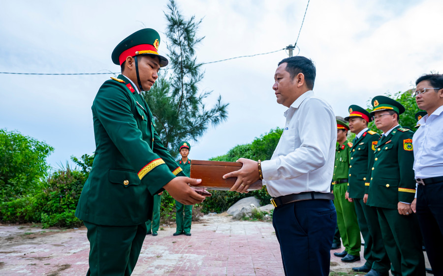 Bí thư Đảng ủy xã Nhơn Châu Nguyễn Tiến Dũng trao cờ cho lực lượng quân đội. Ảnh: Dũng Nhân dsc04884.jpg