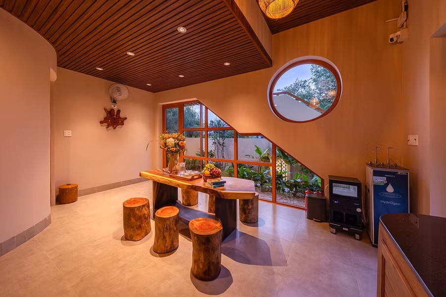 Phòng khách và bếp nhỏ có cửa kính hướng tầm nhìn ra vườn bên hông nhà.