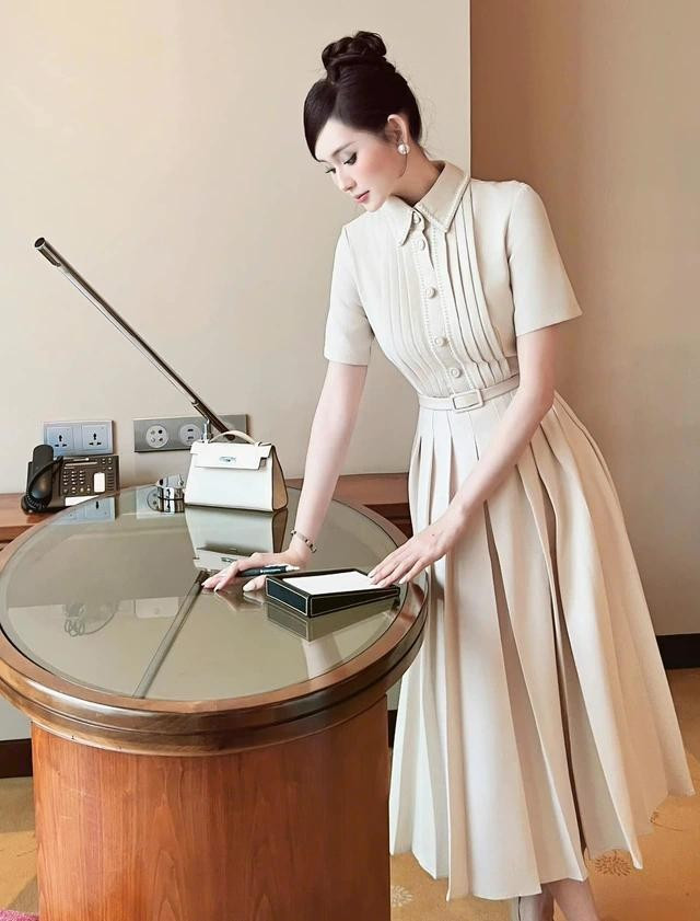 Váy sơ mi dáng dài kết hợp nhiều chi tiết tinh tế, tông màu cream dịu nhẹ giúp nàng tỏa sáng nơi văn phòng, công sở. ẢNH: AR MOUS