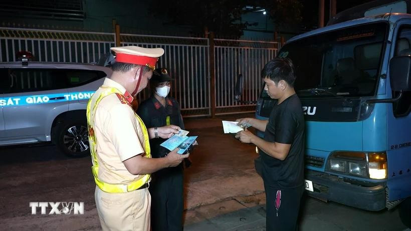Cảnh sát giao thông Công an tỉnh Tây Ninh kiểm tra giấy tờ của lái xe trên tuyến Quốc lộ 22B địa bàn huyện Châu Thành, tỉnh Tây Ninh. (Ảnh: Minh Phú/TTXVN) tai-xe-oto-kinh-doanh-se-bi-phat-toi-5-trieu-dong-neu-lai-xe-lien-tuc-qua-4-gio-dd.jpg