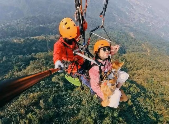 Chị Mai cùng con chó tên Chopper bay dù. ẢNH: NVCC