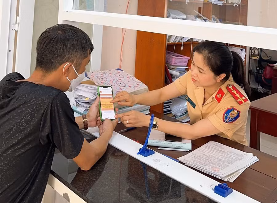 Cán bộ Phòng Cảnh sát Giao thông (Công an tỉnh) hướng dẫn người dân sử dụng dịch vụ công trực tuyến. Ảnh: T.T